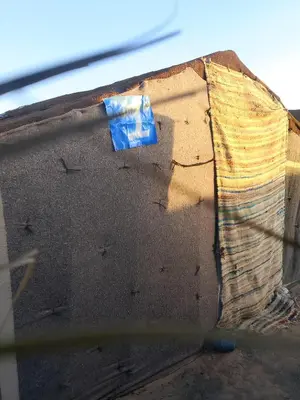 a piece of paper on the side of a building at Travel Oasis Merzouga Camp in Merzouga