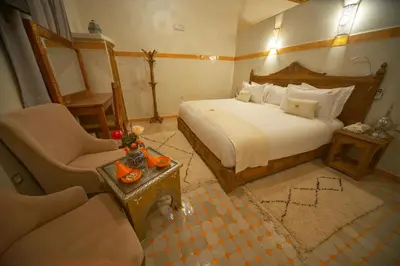 a bedroom with a bed and a couch and a chair at OZ Palace Ouarzazate & SPA in Ouarzazate