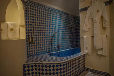 a bathroom with a blue and white tiled tub at OZ Palace Ouarzazate & SPA in Ouarzazate