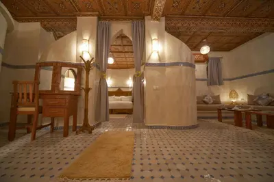 a room with a living room with a bed and a table at OZ Palace Ouarzazate & SPA in Ouarzazate
