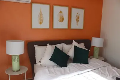 a bedroom with a bed with pillows and two lamps at New Fez Apartments in Fès