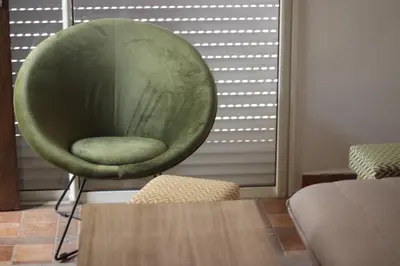 a green chair in a room with a table at New Fez Apartments in Fès