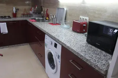 a kitchen with a counter top with a microwave and a dishwasher at New Fez Apartments in Fès