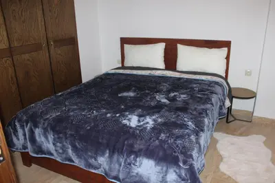 a bedroom with a bed with a blue blanket at New Fez Apartments in Fès