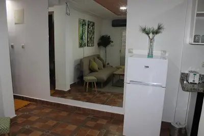 a kitchen with a refrigerator and a living room at New Fez Apartments in Fès