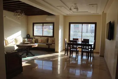 a living room with a table and chairs and a couch at New Fez Apartments in Fès