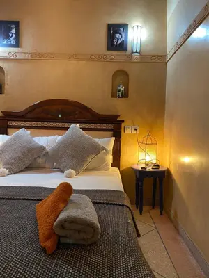 a bedroom with a bed with a wooden head board at Berber Nomad Kasbah in Nkob