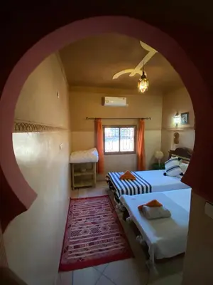 a room with two beds and a window at Berber Nomad Kasbah in Nkob