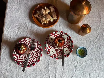 three plates on a table with a bowl of food at Berber Nomad Kasbah in Nkob