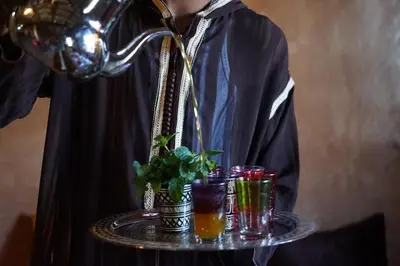 a person holding a tray with drinks on it at Berber Nomad Kasbah in Nkob