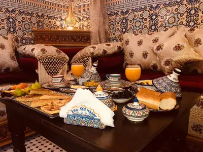 a breakfast table with a tray of food and orange juice at Riad Fes Madaw in Fès