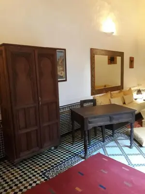 a living room with a table and a couch at Riad Le Sucrier de Fès in Fès