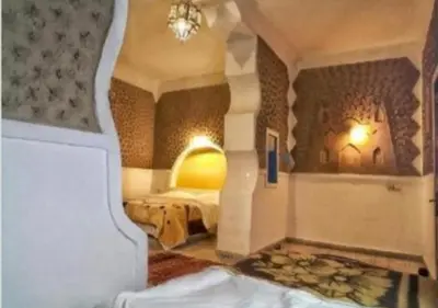 a room with a bedroom with a bed and a fireplace at Casa Laman in Merzouga
