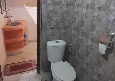 a bathroom with a toilet and a wall at Casa Laman in Merzouga