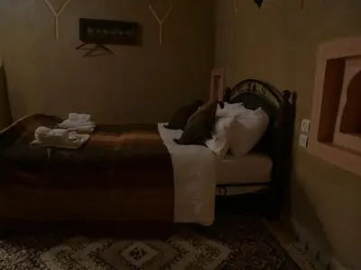 a bedroom with a bed with pillows on it at Casa Laman in Merzouga