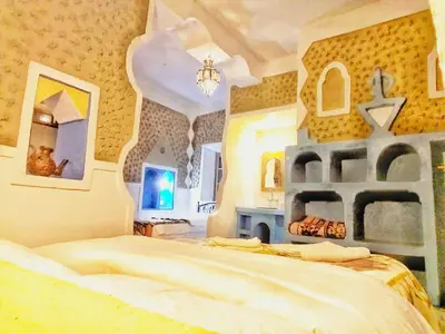 a bedroom with a large bed and a fireplace at Casa Laman in Merzouga