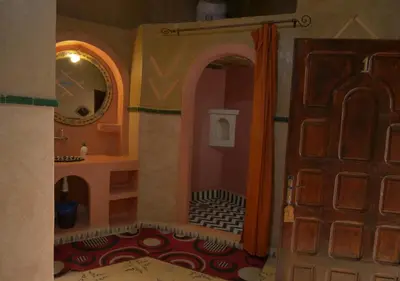 a room with a bathroom with a door and a mirror at Casa Laman in Merzouga