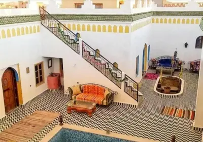 a living room with a staircase and a pool at Casa Laman in Merzouga