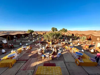 a group of people sitting in chairs in the desert at Desert Camp Laila in Mhamid