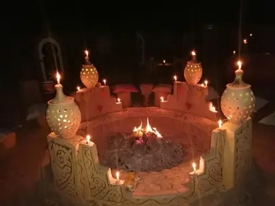a fire pit with candles in the middle at Desert Camp Laila in Mhamid