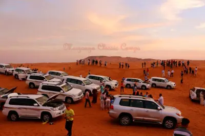a group of cars parked in the desert at Merzouga Authentic Camps in Merzouga
