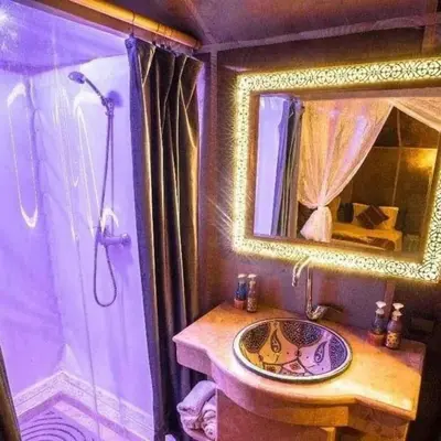 a bathroom with a sink and a shower with a mirror at Sunset Camp Merzouga in Merzouga