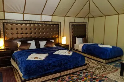a bedroom with two beds in a tent at Sunset Camp Merzouga in Merzouga