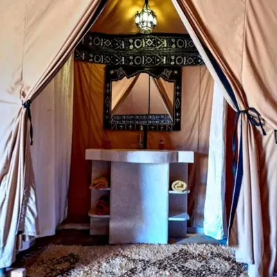 a room with a tent with a table and a mirror at Sunset Camp Merzouga in Merzouga
