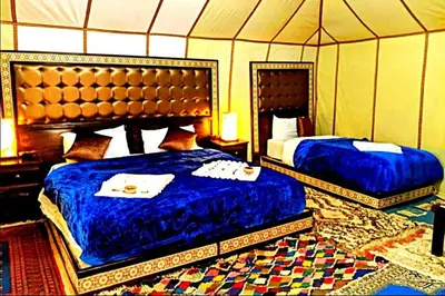 a bedroom with two beds in a tent at Sunset Camp Merzouga in Merzouga