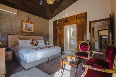 a bedroom with a bed and a table and chairs at Riad Sebti Fès in Fès