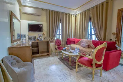 a living room with a red couch and chairs at Riad Sebti Fès in Fès