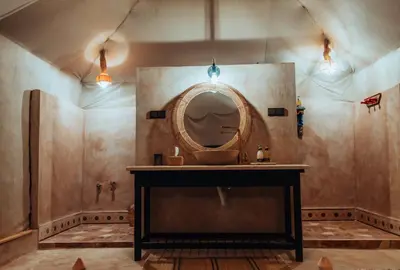 a bathroom with a sink and a mirror on the wall at Royal Nomad Camp in Merzouga