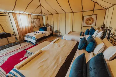 a room with two beds in a tent at Royal Nomad Camp in Merzouga