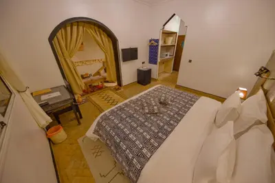 a bedroom with a large bed and a mirror at Tin Joseph in Ouarzazate