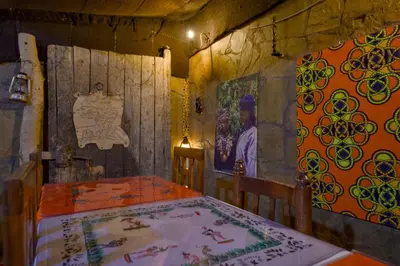 a dining room with a table and a painting on the wall at Tin Joseph in Ouarzazate