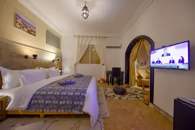a bedroom with a bed and a flat screen tv at Tin Joseph in Ouarzazate