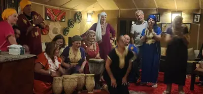a group of people posing for a picture in a room at Nomad Camp Merzouga in Merzouga