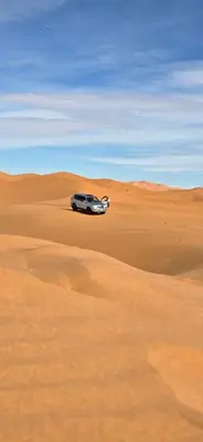 a car parked in the middle of a desert at Nomad Camp Merzouga in Merzouga