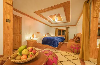 a bedroom with a bed and a bowl of fruit on a table at Hotel Riad Bahammou in Aït Idaïr