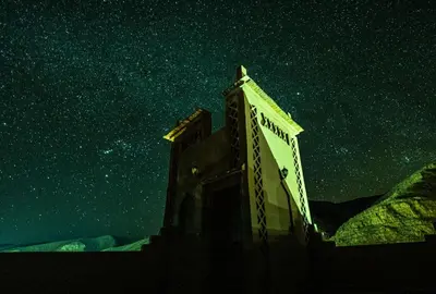 a building under a starry sky at night at Hotel Riad Bahammou in Aït Idaïr
