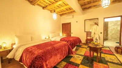 a bedroom with two beds in a room at Hotel Riad Bahammou in Aït Idaïr