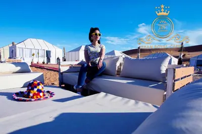 a woman sitting on a couch on a table at ITRAN ROYAL CAMP in Merzouga