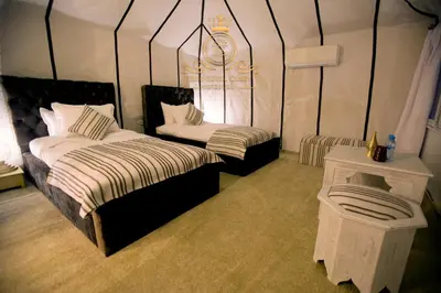 a bedroom with two beds in a tent at ITRAN ROYAL CAMP in Merzouga