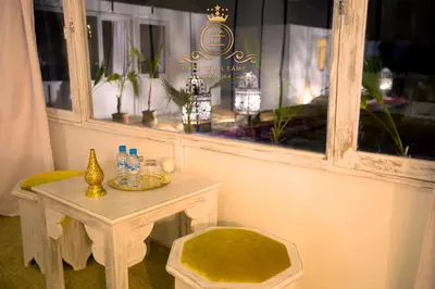 a table with a chair next to a window at ITRAN ROYAL CAMP in Merzouga