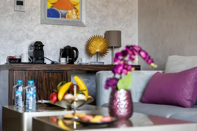 a living room with a table with a vase of flowers at Nour Plazza Hotel in Fès