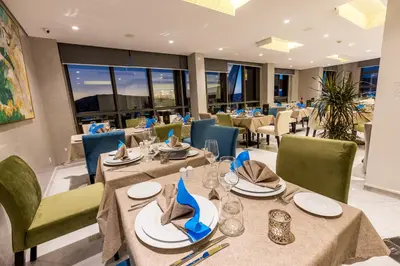 a dining room with tables and chairs in a restaurant at Nour Plazza Hotel in Fès