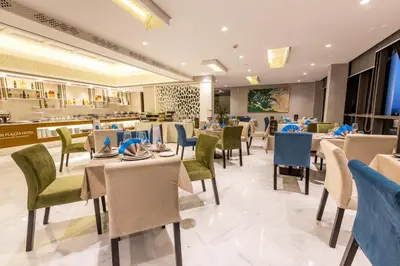 a restaurant with tables and chairs and a buffet at Nour Plazza Hotel in Fès