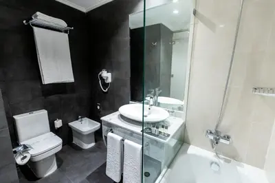 a bathroom with a sink and a toilet and a shower at Nour Plazza Hotel in Fès