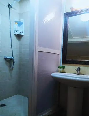 a bathroom with a shower and a sink and a mirror at Maison d'hôtes Jnan Atlas in Sidi Abdalwahad