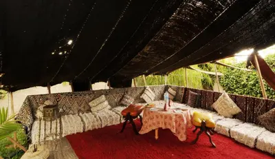 a living room with a couch and a table with a candle at Maison d'hôtes Jnan Atlas in Sidi Abdalwahad